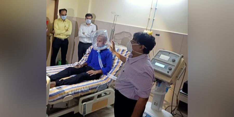 Dr Ganapathi and his team with a patient wearing a bubble helmet